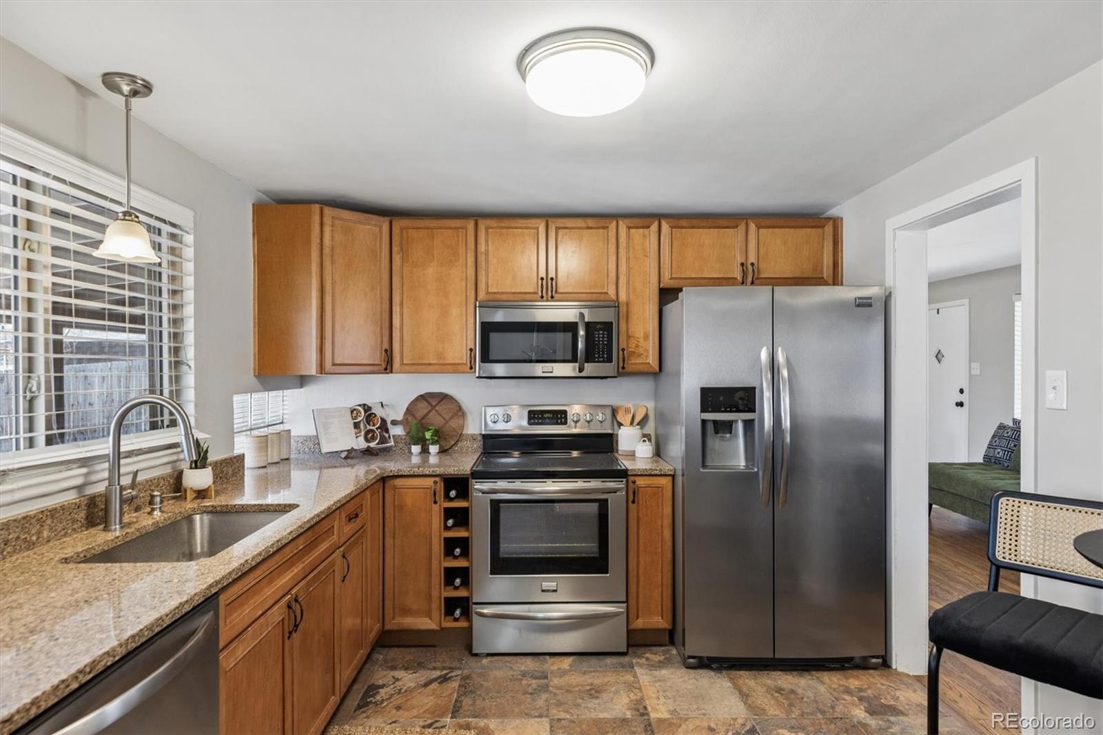 4170 North Lamar Street Wheat Ridge, CO 80033 - Photo 11 of 26 a kitchen with stainless steel appliances granite countertop a refrigerator a stove a sink and a microwave