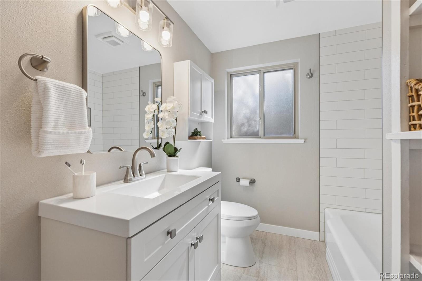 4170 North Lamar Street Wheat Ridge, CO 80033 - Photo 14 of 26 a bathroom with a sink toilet and mirror