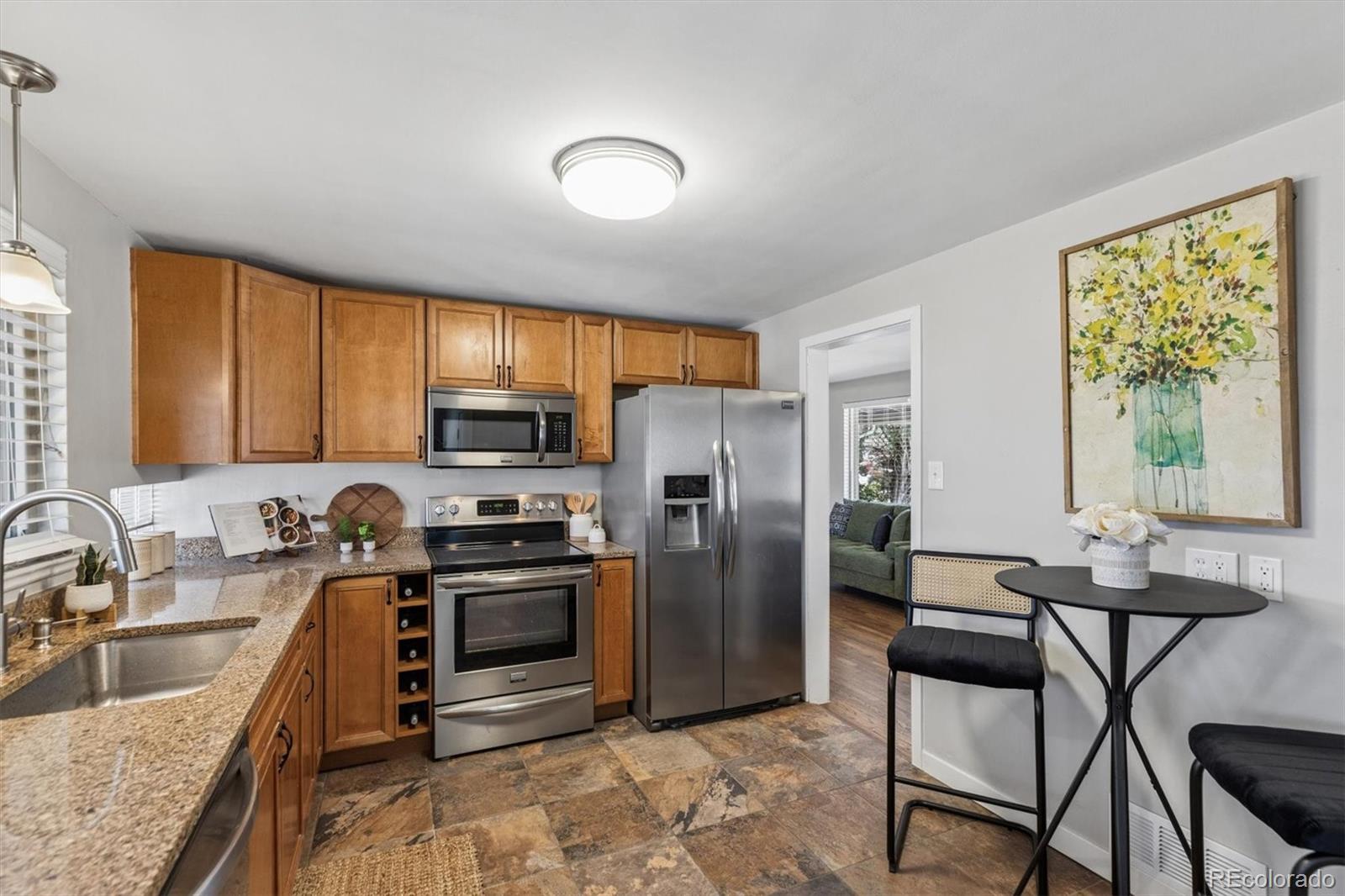4170 North Lamar Street Wheat Ridge, CO 80033 - Photo 9 of 26 a kitchen with a stove a sink and a refrigerator