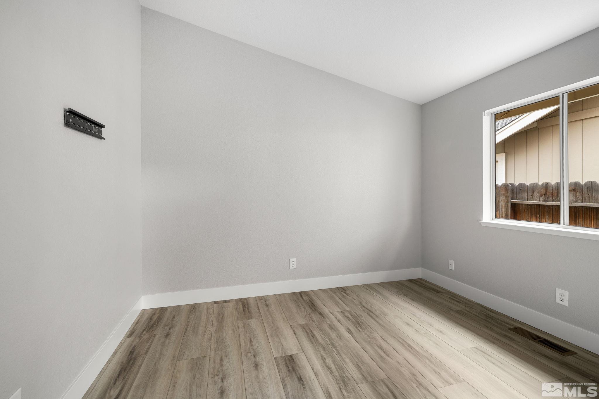 7577 Water View Way Reno, NV 89511 - Photo 11 of 20 a view of an empty room with wooden floor and a window