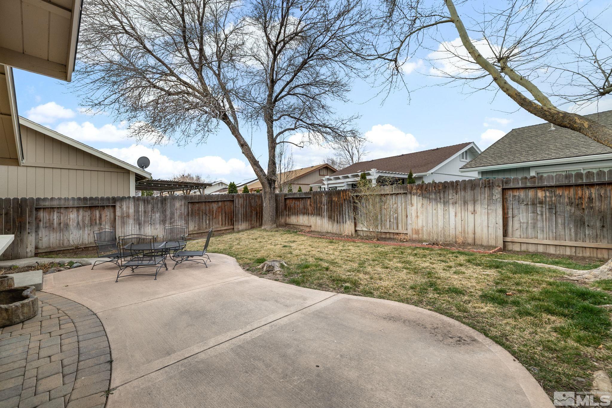 7577 Water View Way Reno, NV 89511 - Photo 17 of 20 a backyard of a house with table and chairs under an umbrella