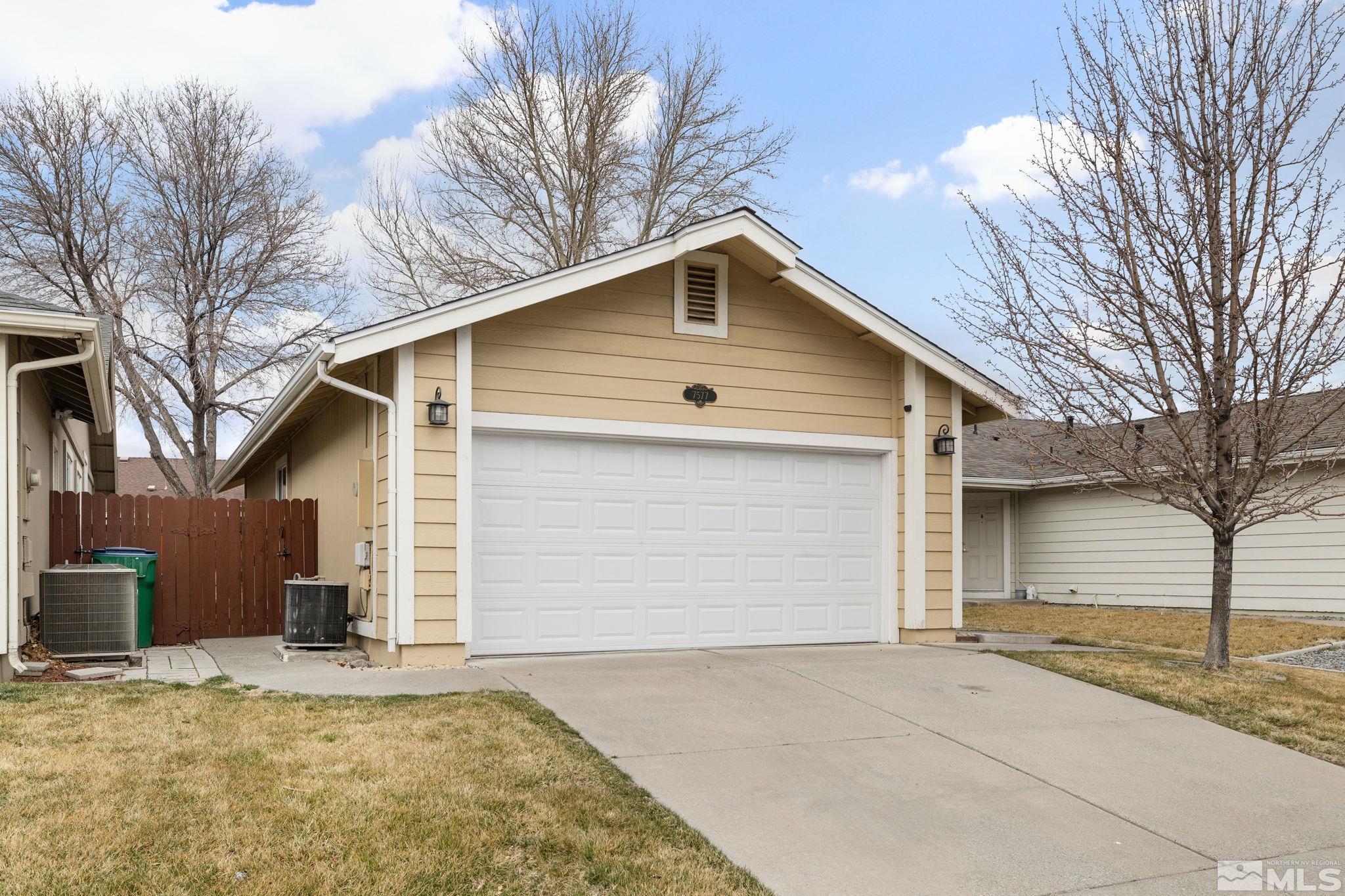 7577 Water View Way Reno, NV 89511 - Photo 2 of 20 a front view of a house with a yard and garage