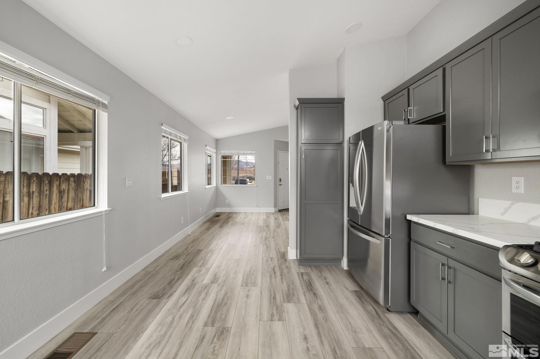 7577 Water View Way Reno, NV 89511 - Photo 8 of 20 a kitchen with stainless steel appliances a refrigerator and wooden floor