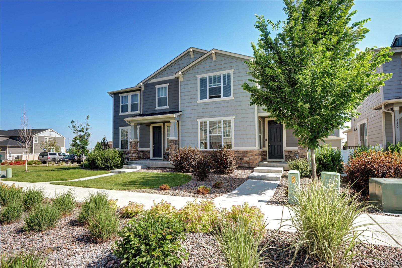 a front view of a house with a yard outdoor seating and covered with trees