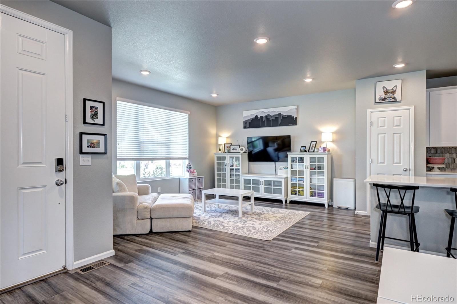 952 Morning Glory Road Brighton, CO 80640 - Photo 2 of 21 a living room with furniture a flat screen tv and a table