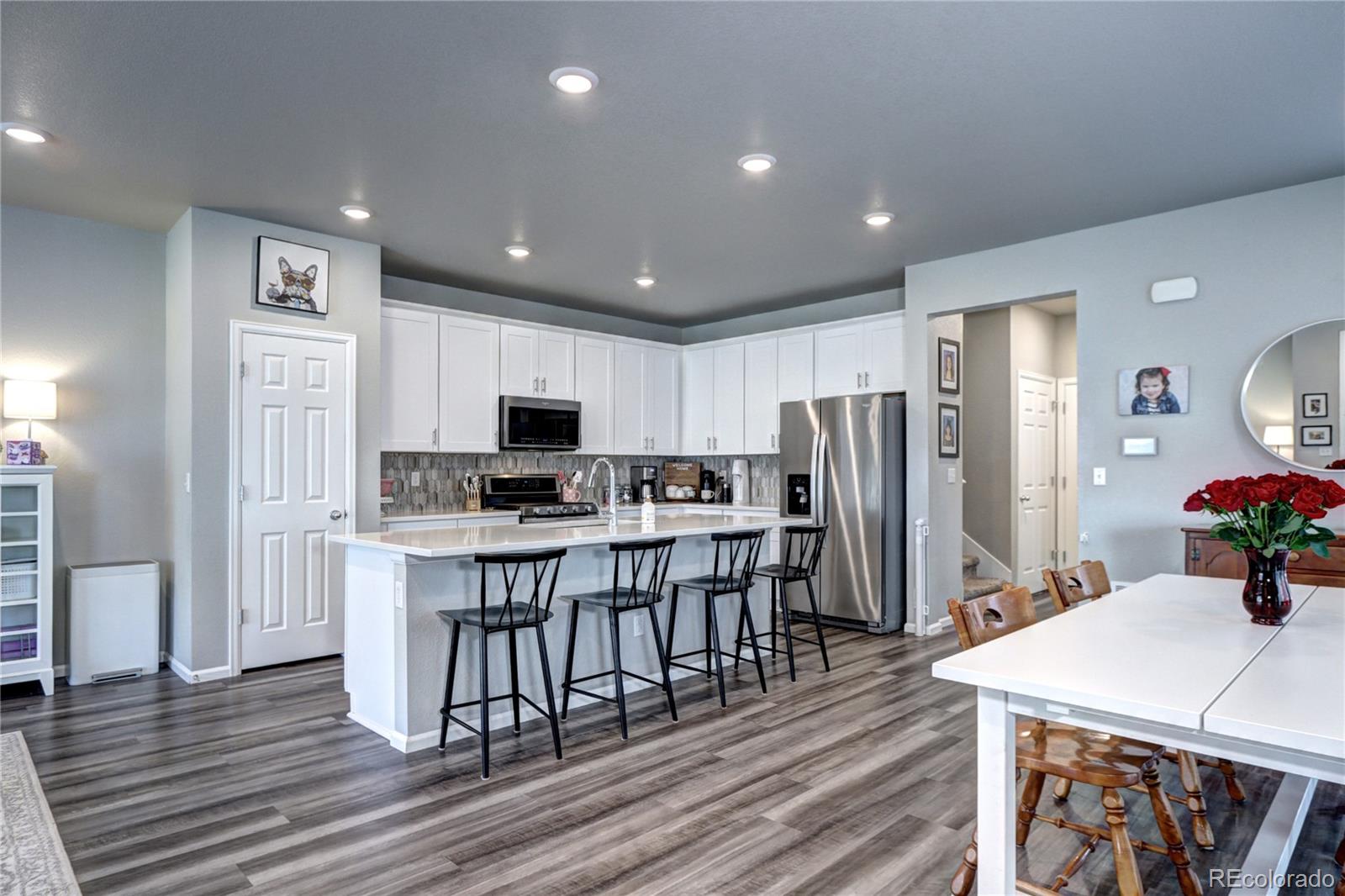 952 Morning Glory Road Brighton, CO 80640 - Photo 6 of 21 a kitchen with stainless steel appliances wooden floor and refrigerator