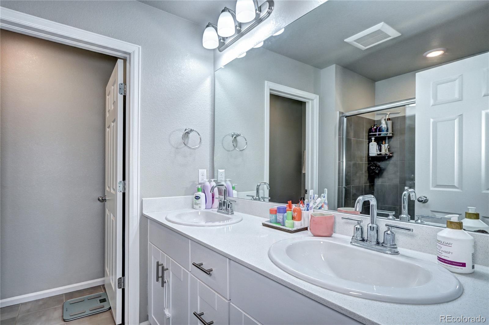 952 Morning Glory Road Brighton, CO 80640 - Photo 10 of 21 a bathroom with double vanity sinks and a mirror