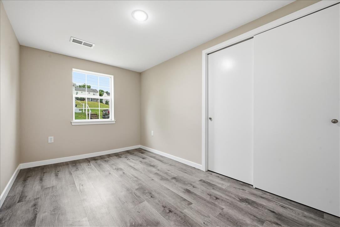 5641 North Coplay Road Whitehall, PA 18052 - Photo 21 of 68 Well-lit room with wood-like flooring, a window, and convenient closet access.