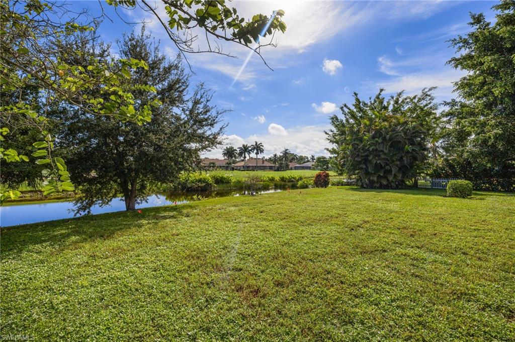 379 Torrey Pines Point Naples, FL 34113 - Photo 18 of 21 Expansive green lawn with mature trees and a tranquil water feature