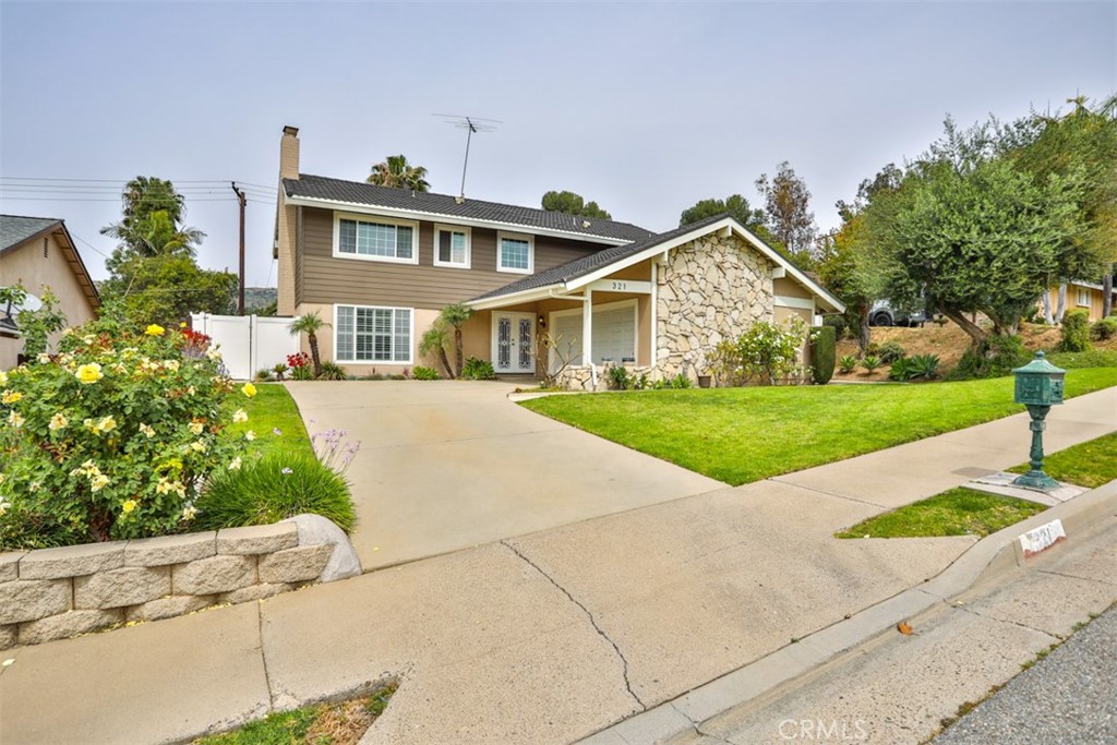 a front view of a house with a yard and potted plants
