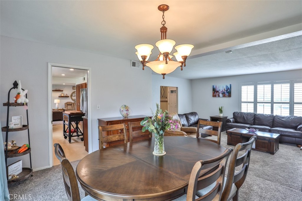 321 Blossom Place Brea, CA 92821 - Photo 11 of 48 a dining room with wooden floor a chandelier a glass table and chairs