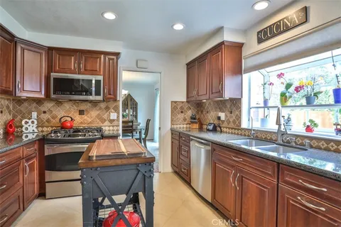 a kitchen with granite countertop a sink stove and microwave