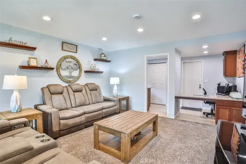 a living room with furniture a clock on wall and a table