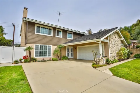 a front view of a house with a yard and potted plants