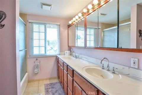 a bathroom with a double vanity sink window and a bathtub