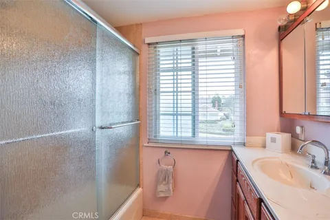 a bathroom with a granite countertop sink and a bathtub