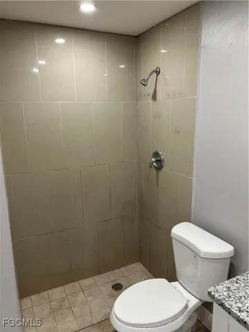 a white toilet sitting next to a bathroom sink and a shower