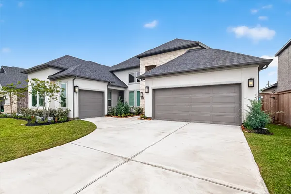a front view of a house with a garden and yard