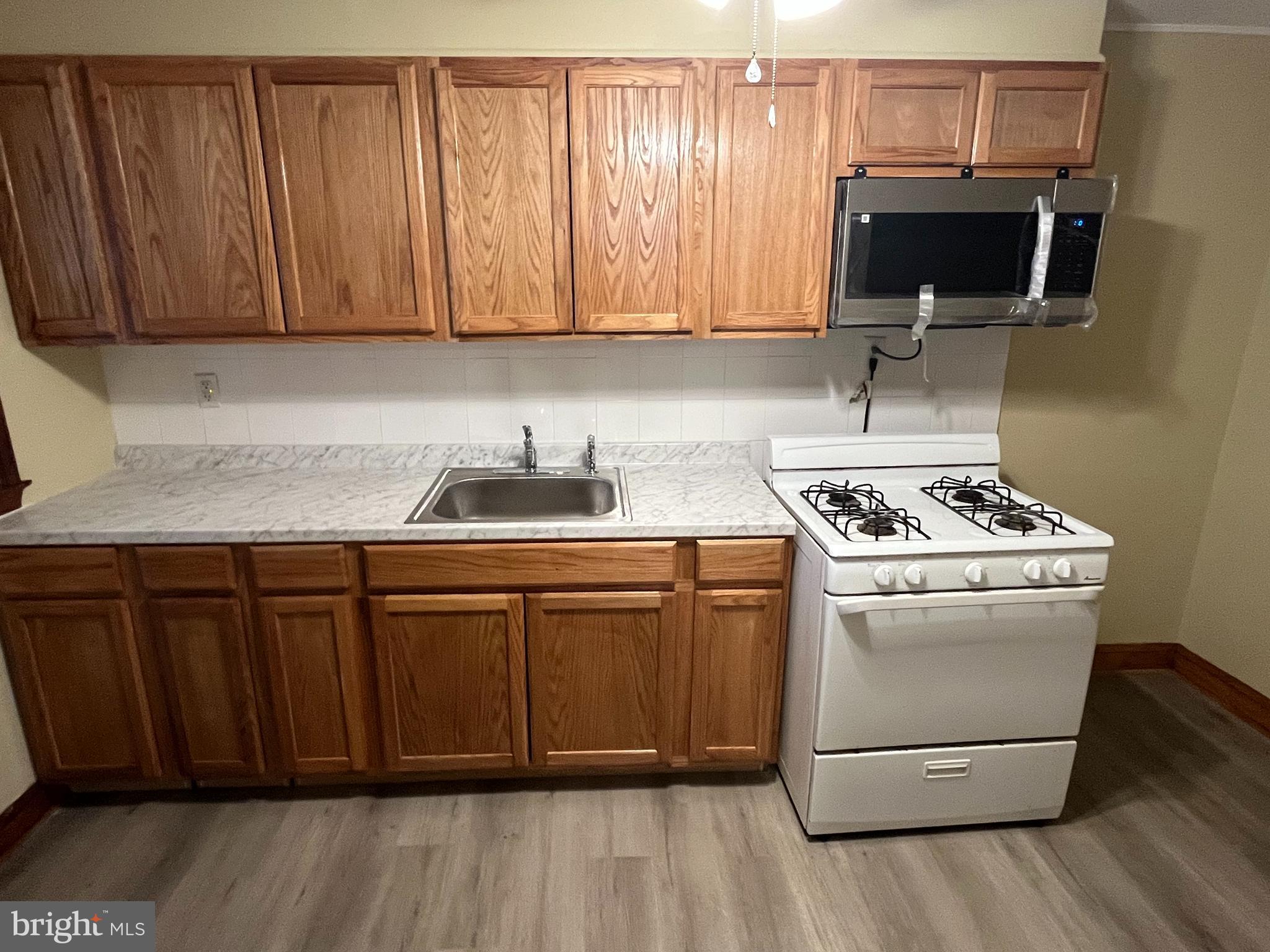 4931 Sinclair Lane Baltimore, MD 21206 - Photo 6 of 11 a kitchen with granite countertop wooden cabinets and a stove top oven