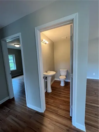 a view of an empty room with wooden floor and windows