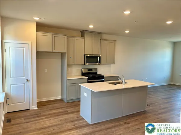a kitchen with wooden floor and stainless steel appliances