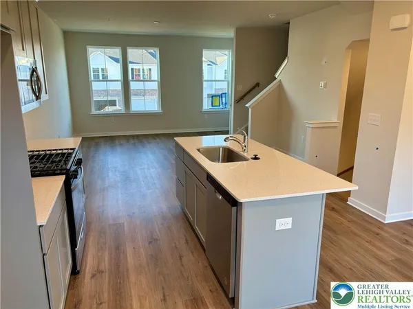 a kitchen with a sink and wooden floor