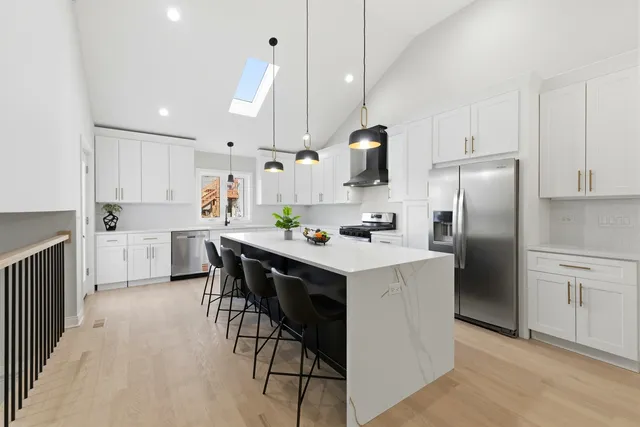a kitchen with white cabinets and stainless steel appliances