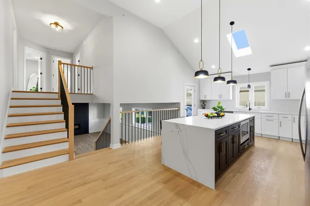 a kitchen with kitchen island a sink stove and wooden floor