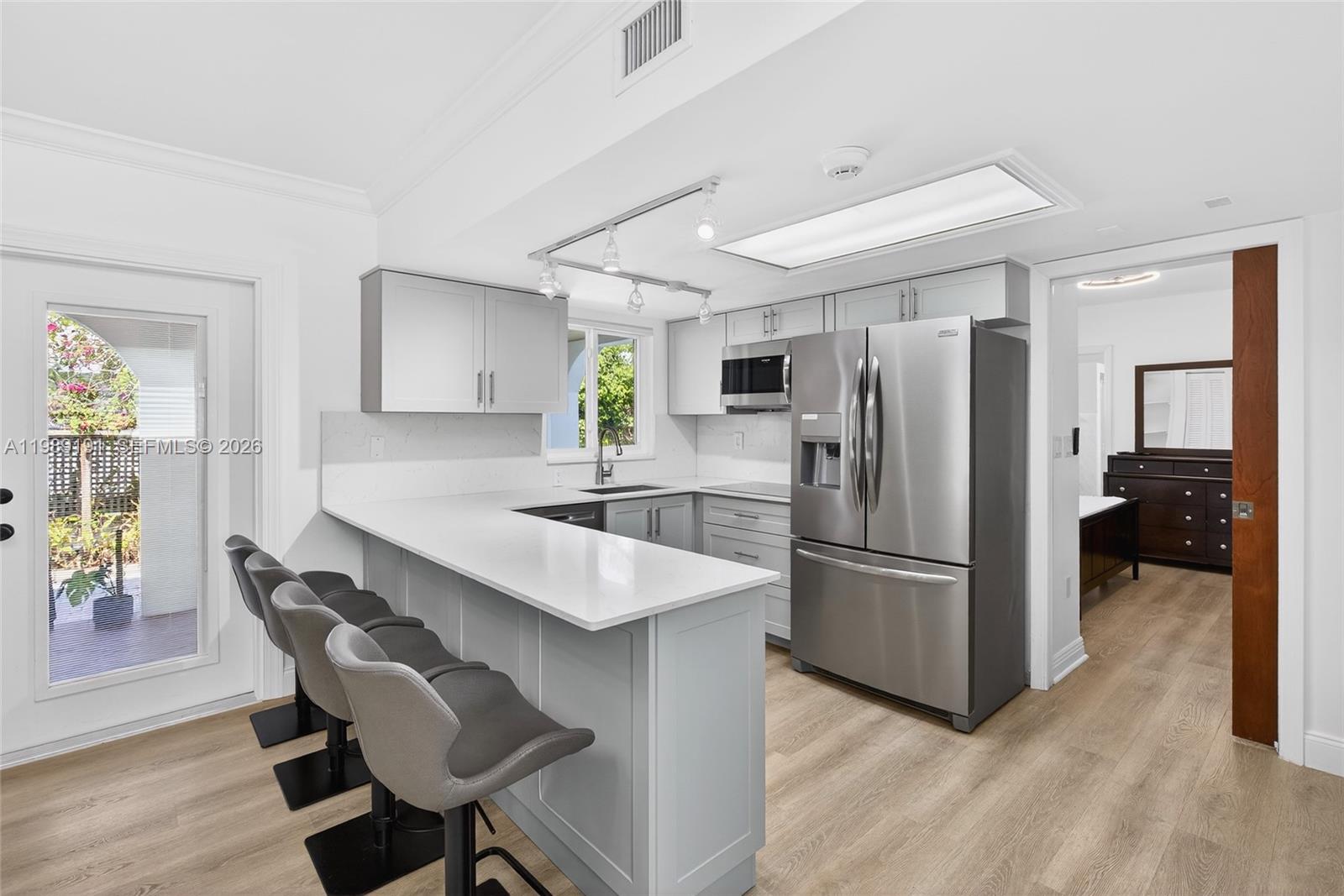 2431 Southwest 4th Street Miami, FL 33135 - Photo 12 of 33 a kitchen with kitchen island a appliances dining table and a refrigerator