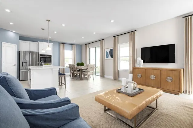 a living room with furniture a flat screen tv and kitchen view