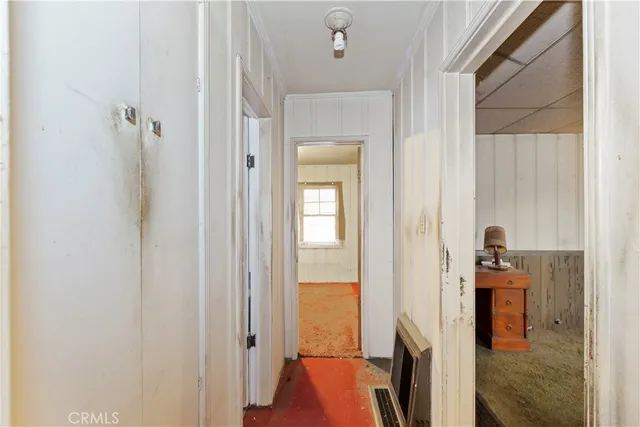 a view of a hallway with a livingroom and a bathroom