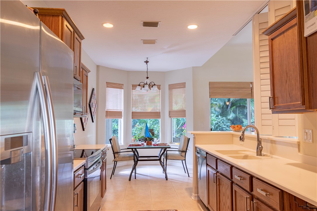 671 Gossamer Wing Way Sebastian, FL 32958 - Photo 16 of 36 a kitchen with stainless steel appliances granite countertop sink stove and refrigerator