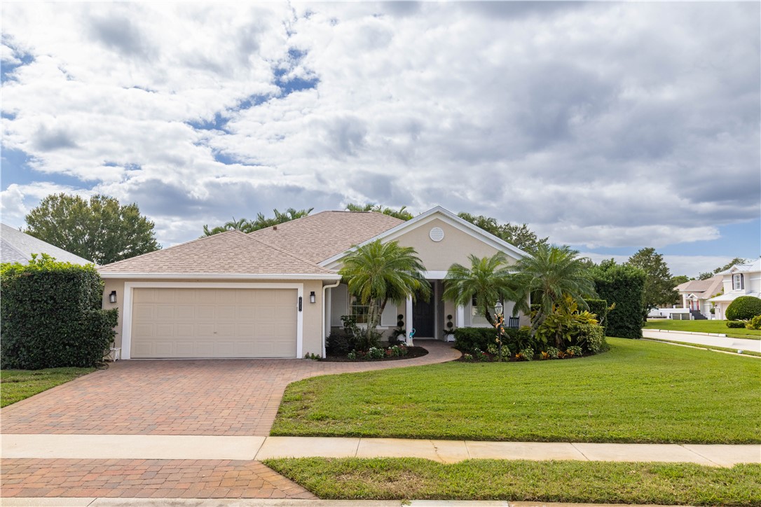 671 Gossamer Wing Way Sebastian, FL 32958 - Photo 5 of 36 a view of a white house next to a yard with big trees