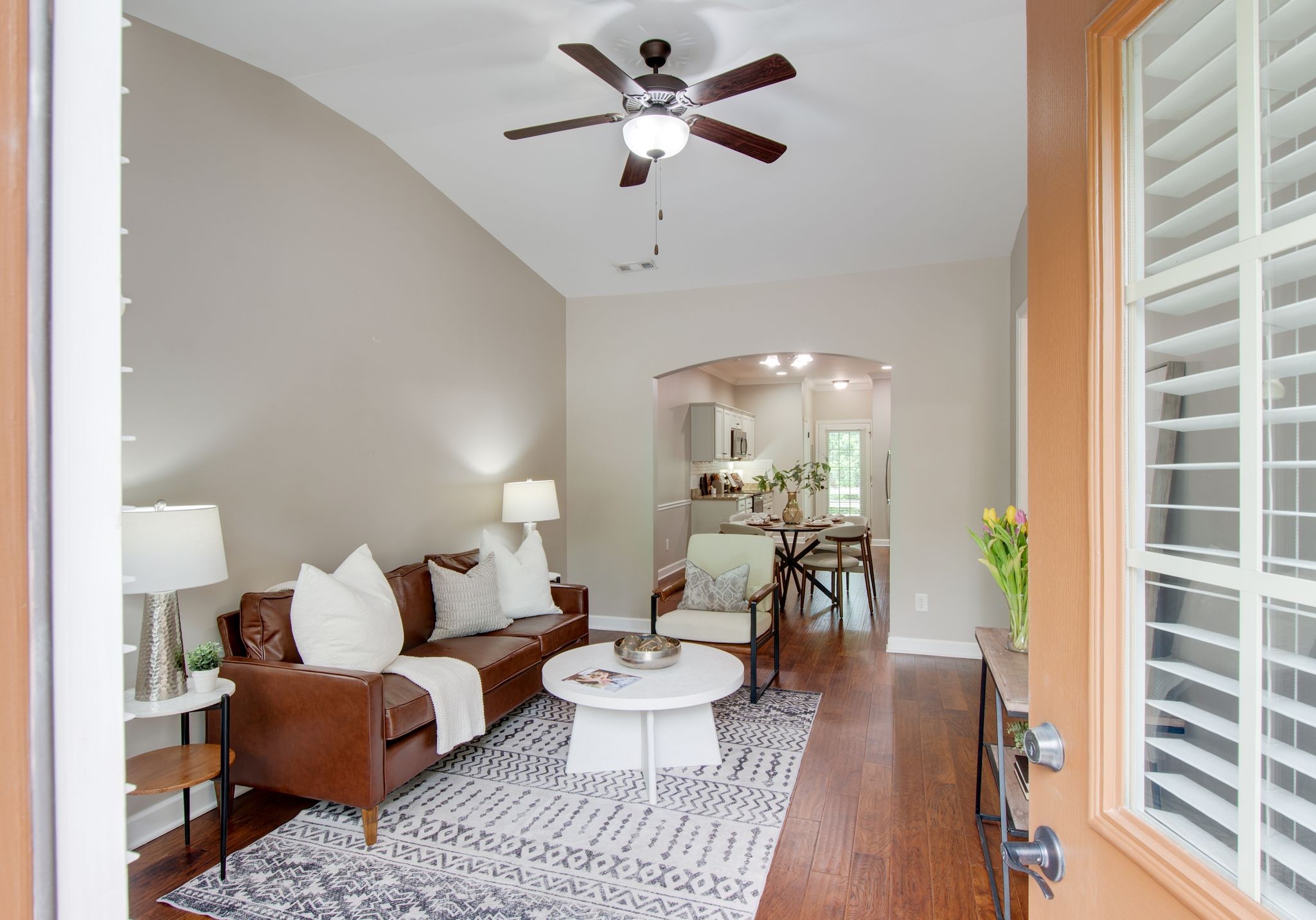a living room with furniture a chandelier and a dining room