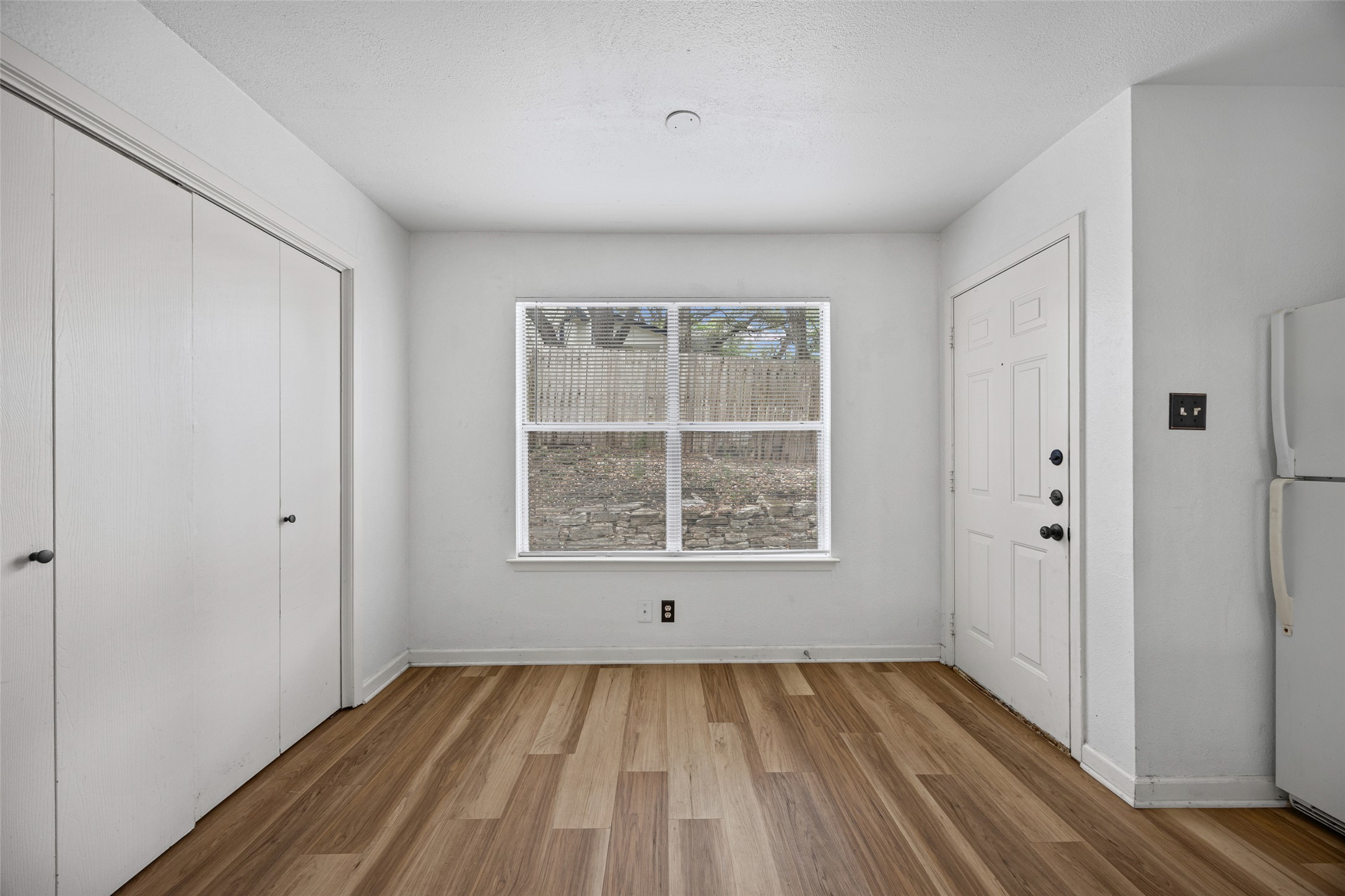 8100 Dunn Street, Unit B Austin, TX 78745 - Photo 11 of 29 a view of an empty room with wooden floor and a window