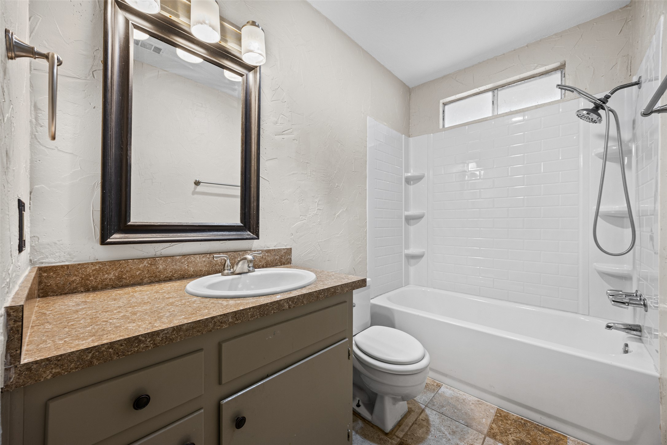 8100 Dunn Street, Unit B Austin, TX 78745 - Photo 18 of 29 a bathroom with a granite countertop bathtub shower sink vanity and toilet