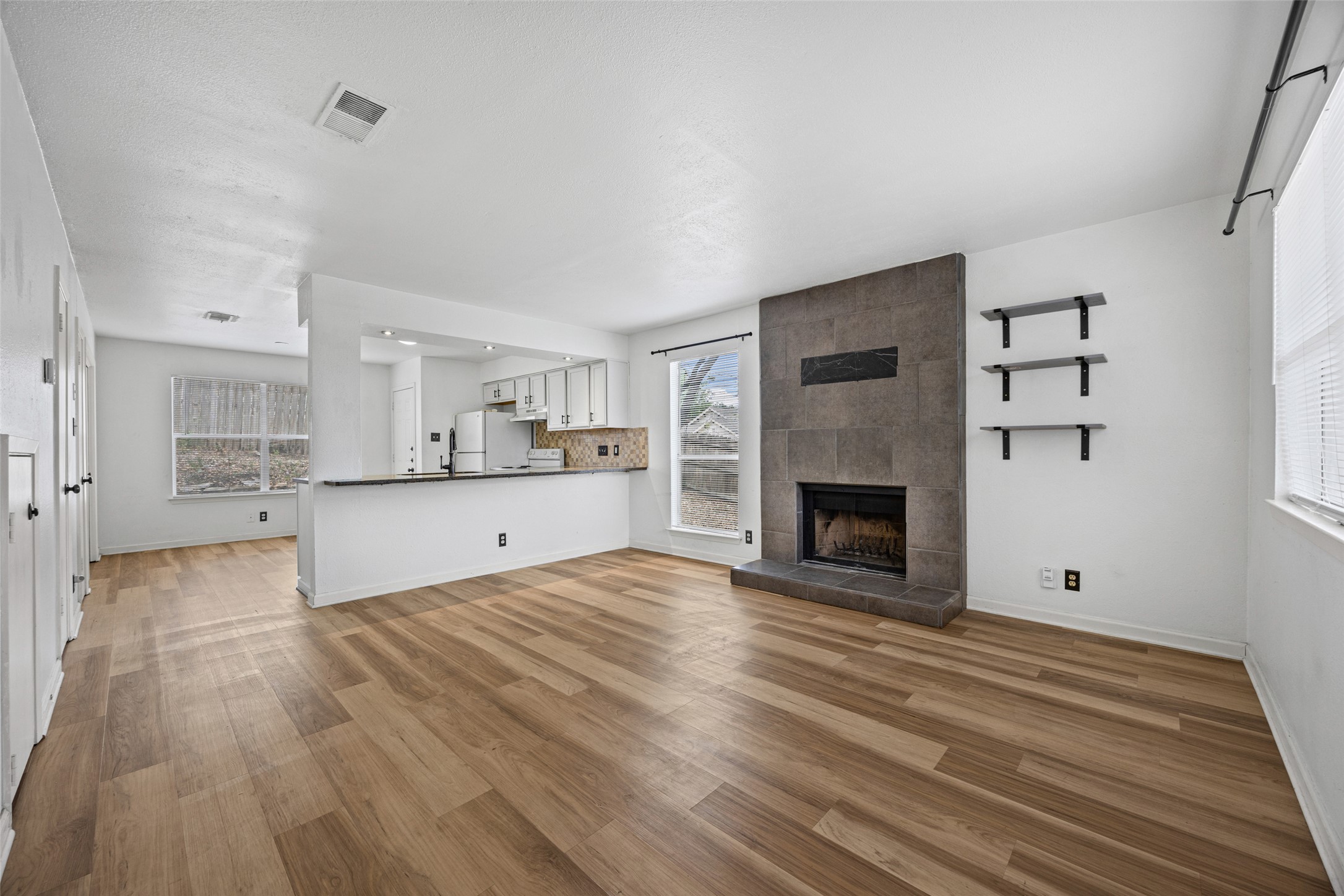 8100 Dunn Street, Unit B Austin, TX 78745 - Photo 5 of 29 a view of kitchen and empty room with wooden floor