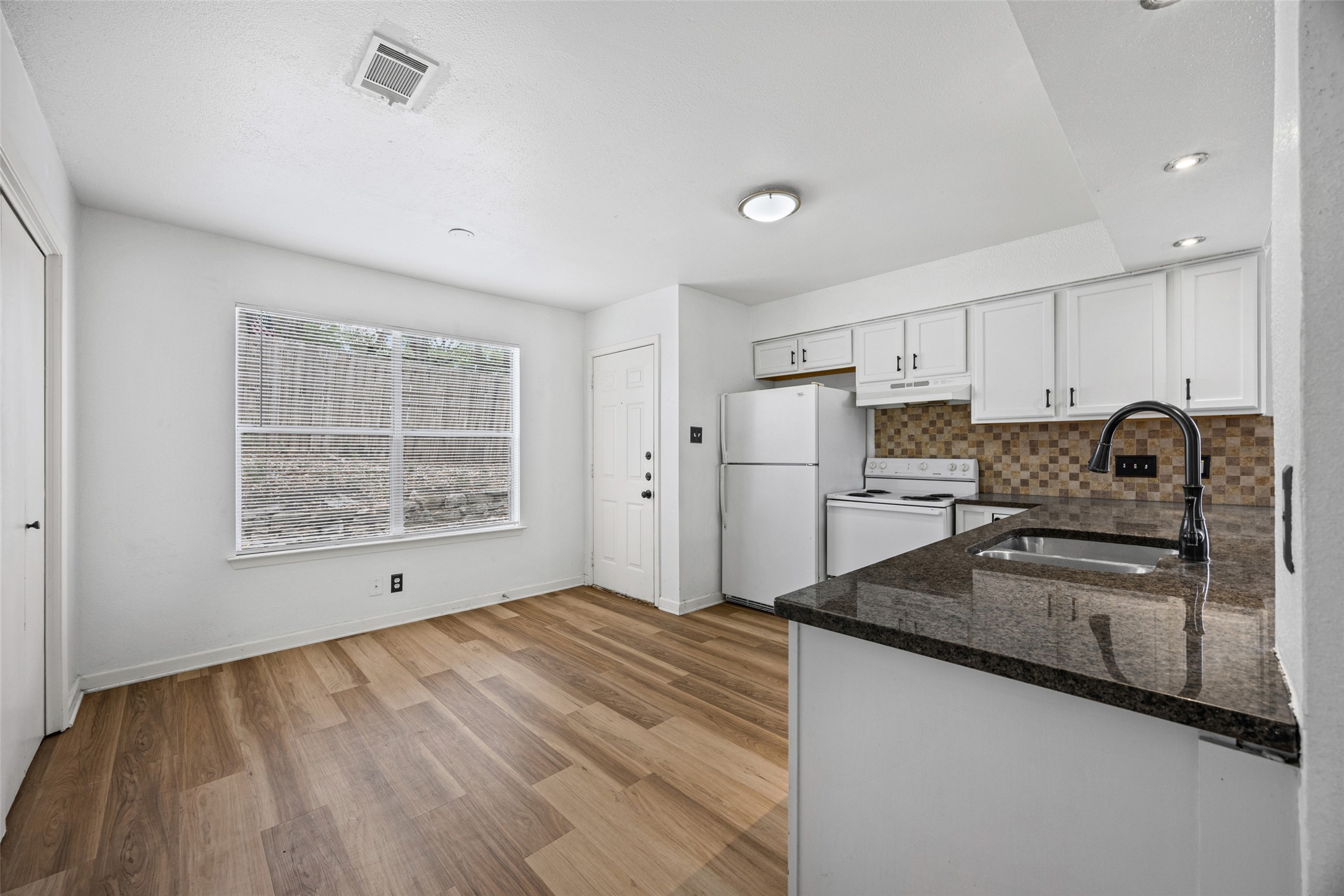8100 Dunn Street, Unit B Austin, TX 78745 - Photo 8 of 29 a kitchen with granite countertop a refrigerator and a stove top oven