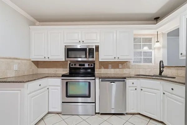 a kitchen with white cabinets stainless steel appliances and sink