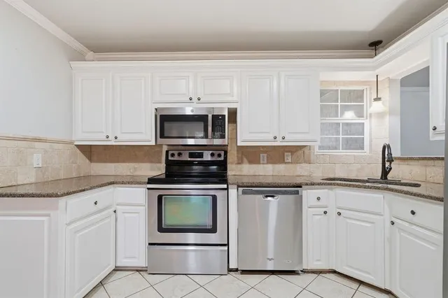 a kitchen with white cabinets stainless steel appliances and sink