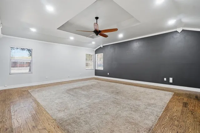 an empty room with ceiling fan and window