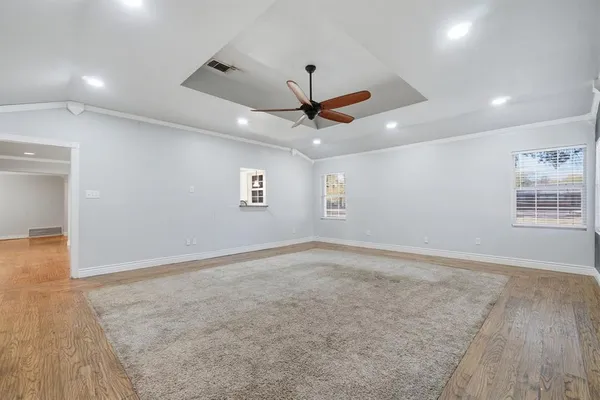 an empty room with windows and fan