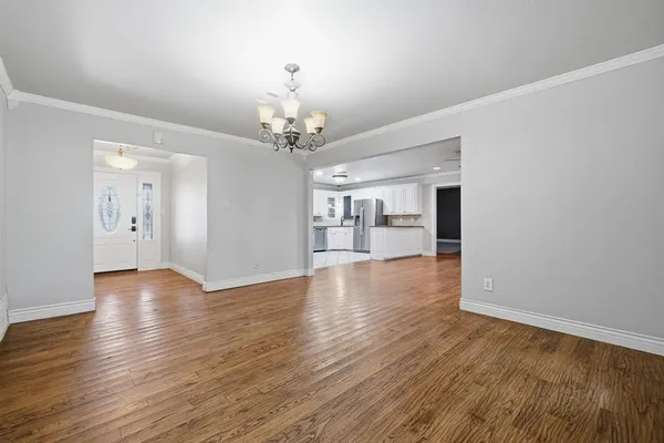a view of a room with wooden floor and kitchen view