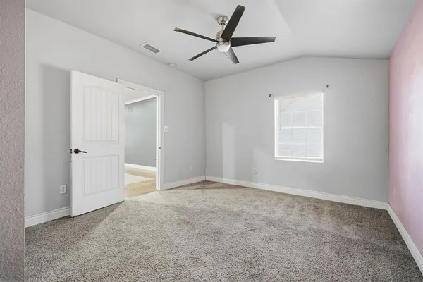 a view of a livingroom with a ceiling fan & windows