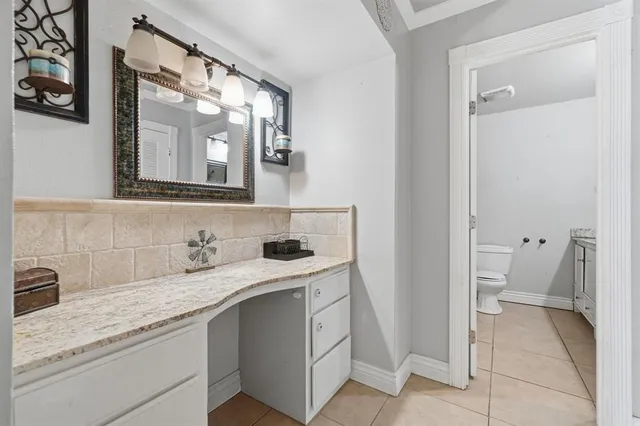 a en suite bathroom with a granite countertop sink and a mirror