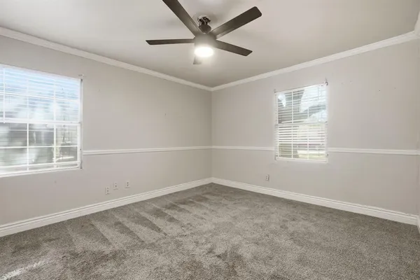 an empty room with a window and a fan