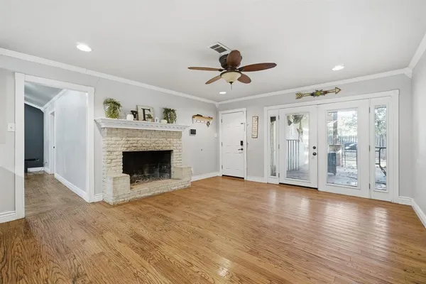 a view of a livingroom with wooden floor and a kitchen