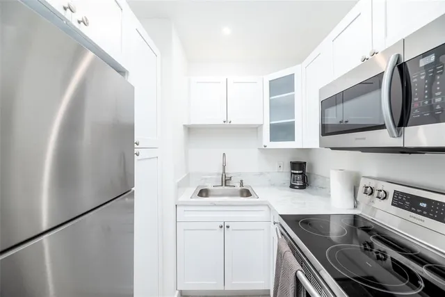 a kitchen with stainless steel appliances a sink stove and refrigerator