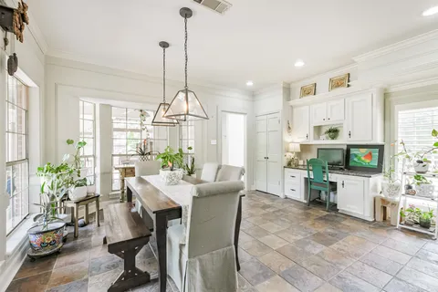 a view of a dining room and livingroom with furniture wooden floor a chandelier