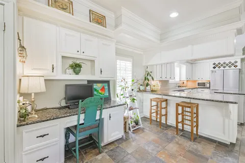 a kitchen with cabinets and chairs
